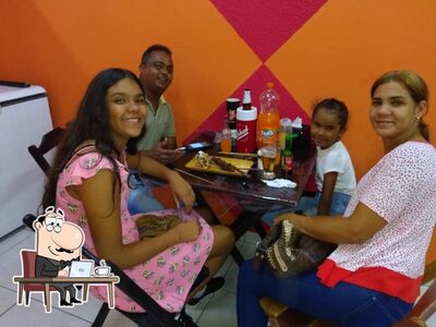 Sente em uma das mesas no Esquina do Espetinho