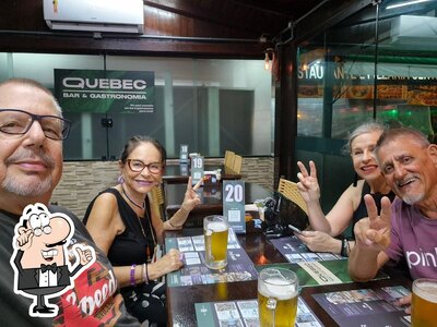 Sente em uma das mesas no Quebec Bar e Gastronomia