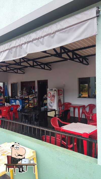 Sente em uma das mesas no Lanchonete e Pizzaria do Dilinha