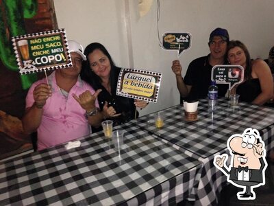 Sente em uma das mesas no Restaurante e Pizzaria Rancho da Lua