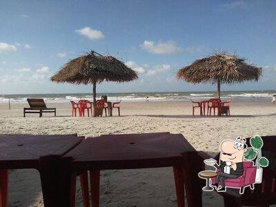 Sente em uma das mesas no Bar Mar Aberto