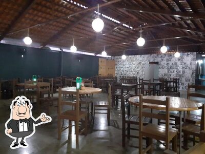 Sente em uma das mesas no Restaurante e Pizzaria da Rita