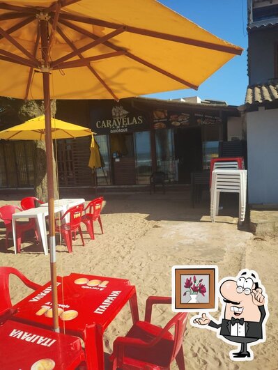 Sente em uma das mesas no Quiosque Caravelas