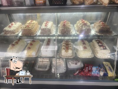 Sente em uma das mesas no Padaria e confeitaria do Chris pães doces e salgados