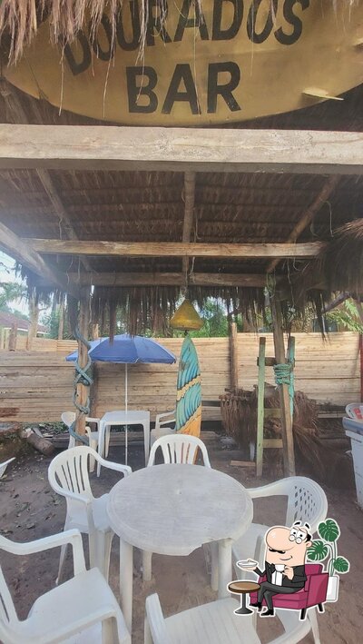 Sente em uma das mesas no DOURADOS HOUSE BAR