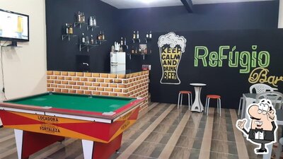 Sente em uma das mesas no REFÚGIO BAR