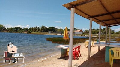 Sente em uma das mesas no Lagoa dos Tambaquis Beach Club