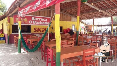 Sente em uma das mesas no Barraca Do Barbado