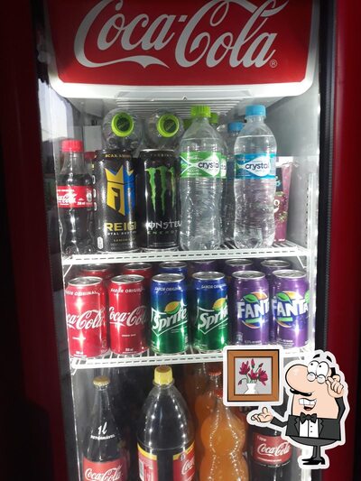 Sente em uma das mesas no CT COMERCIAL- BEBIDAS & ALIMENTOS ME