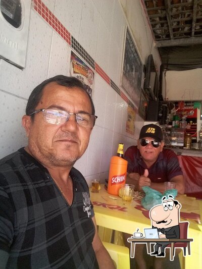 Sente em uma das mesas no Bar Do Rege