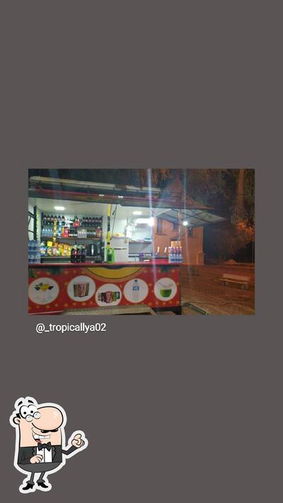 Sente em uma das mesas no Tropicallya lanches