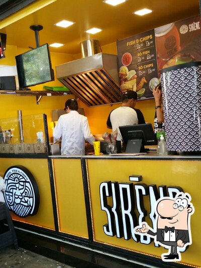 Sente em uma das mesas no Sirène