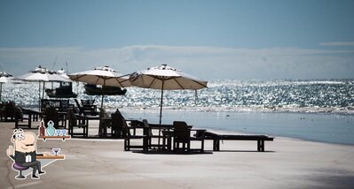 Sente em uma das mesas no Cabana Silvana E Cia Praia