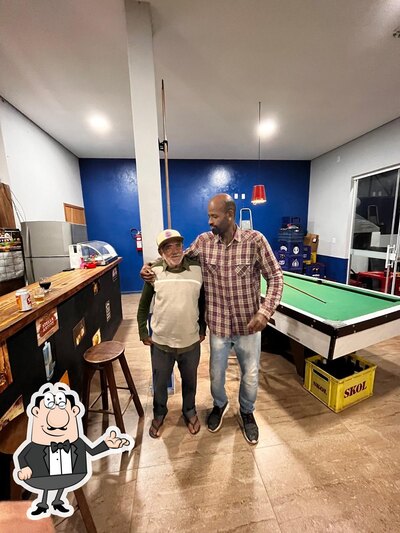 Sente em uma das mesas no Ricardo Bar e Conveniência
