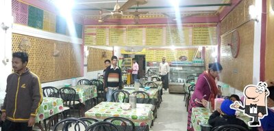 Take a seat at one of the tables at ময়ূৰ হোটেল এণ্ড ৰেষ্টুৰেণ্ট