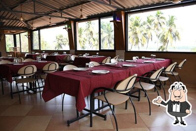 Take a seat at one of the tables at River Isle Multicuisine Restaurant and Bar