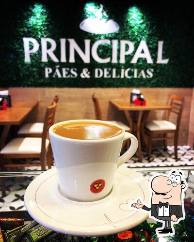 Sente em uma das mesas no Principal Pães e Delícias