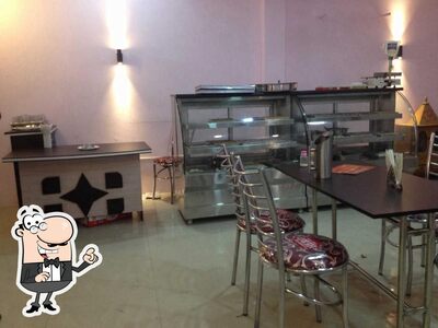 Take a seat at one of the tables at Apurva Ras Restaurant