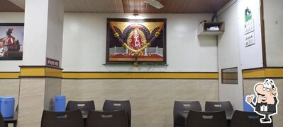Take a seat at one of the tables at Hotel Vighnaharta Rajgurunagar