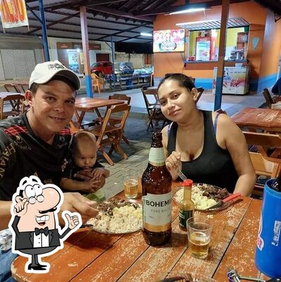 Sente em uma das mesas no BAR DO CABELUDO M.P