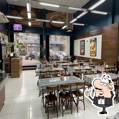 Sente em uma das mesas no Restaurante e Lancheria Dois Irmãos