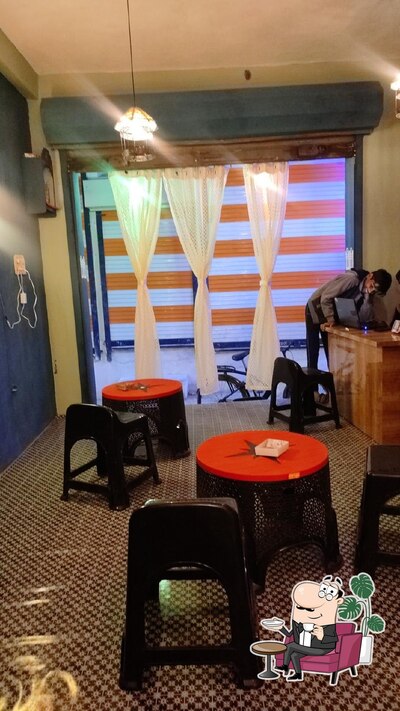 Take a seat at one of the tables at Apna Cafe
