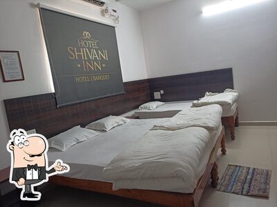 Take a seat at one of the tables at Shivani Inn Hotel & Banquet