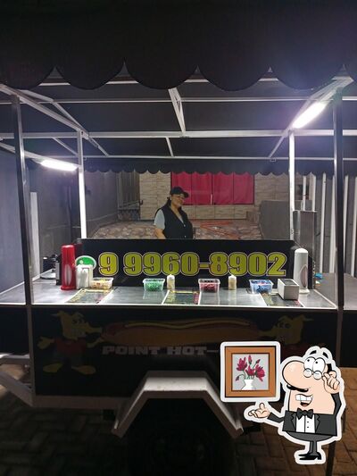Sente em uma das mesas no Point Hot Dog