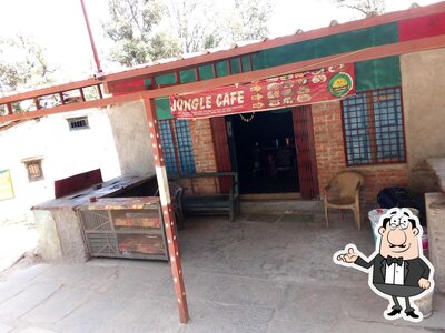 Take a seat at one of the tables at Jungle Cafe- Restaurant