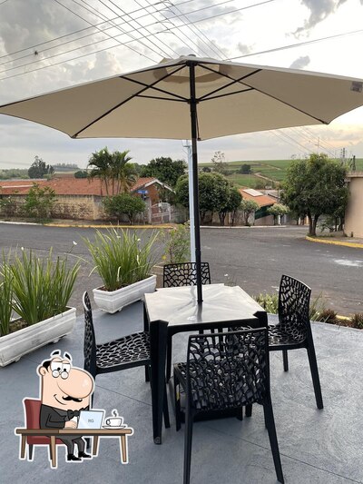 Sente em uma das mesas no AGUIRRA Esfiharia