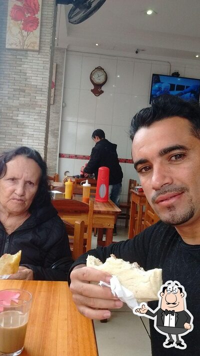 Sente em uma das mesas no Pastelaria Yasmin
