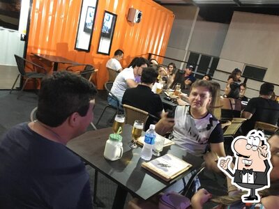 Sente em uma das mesas no O Complexo Bar