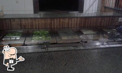 Sente em uma das mesas no Espetos Grill