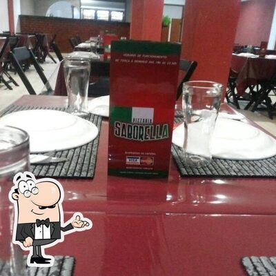 Sente em uma das mesas no Pizzaria Saborella
