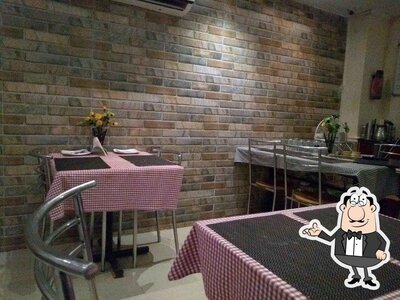 Take a seat at one of the tables at Arya Mahal Restaurant