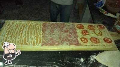 Sente em uma das mesas no Neuzas Bar E Pizzaria