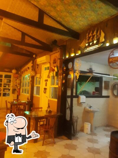 Sente em uma das mesas no pizzaria Capitão Mainha
