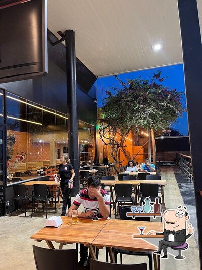 Sente em uma das mesas no Galeria da Pizza Km 06