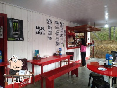 Sente em uma das mesas no BANCA DO PASTEL JULIANO