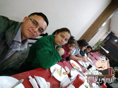 Sente em uma das mesas no Alpes Pizzaria e Restaurante