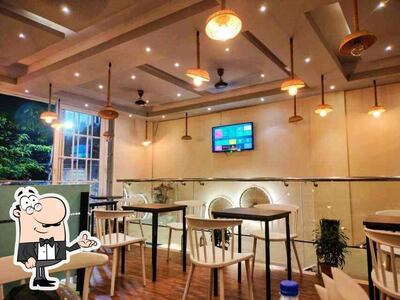 Take a seat at one of the tables at Cheesecake Factory - Cafe Vairagi