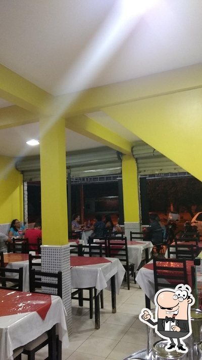 Sente em uma das mesas no Crocodilu's Pizzaria