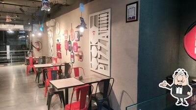Take a seat at one of the tables at Pizza Hut Parvathi Nagar, Bellary