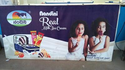 The advertisement displays information about KMF NANDINI MILK PARLOUR