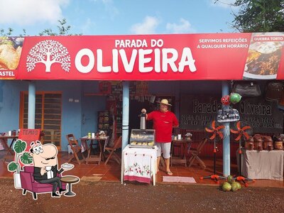 Sente em uma das mesas no Parada Do OLIVEIRA