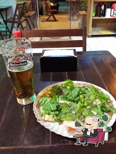 Sente em uma das mesas no Budega Bar Pizzaria