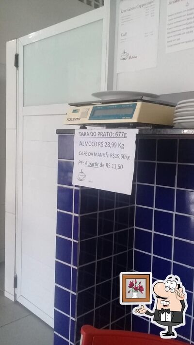 Sente em uma das mesas no Lanchonete Delícias