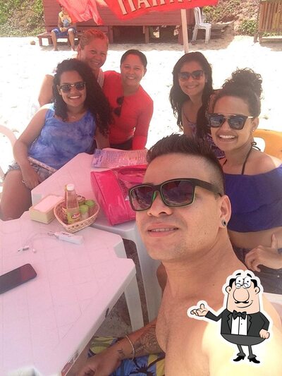 Sente em uma das mesas no Barraca Amor Beach