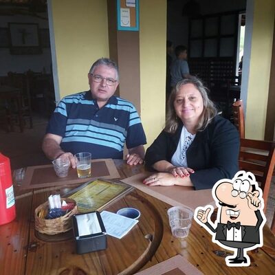 Sente em uma das mesas no Restaurante Cachoeira do Escorrega / Camping