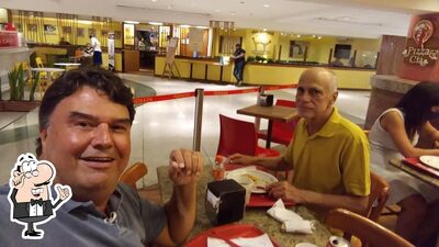 Sente em uma das mesas no Pizza & Cia